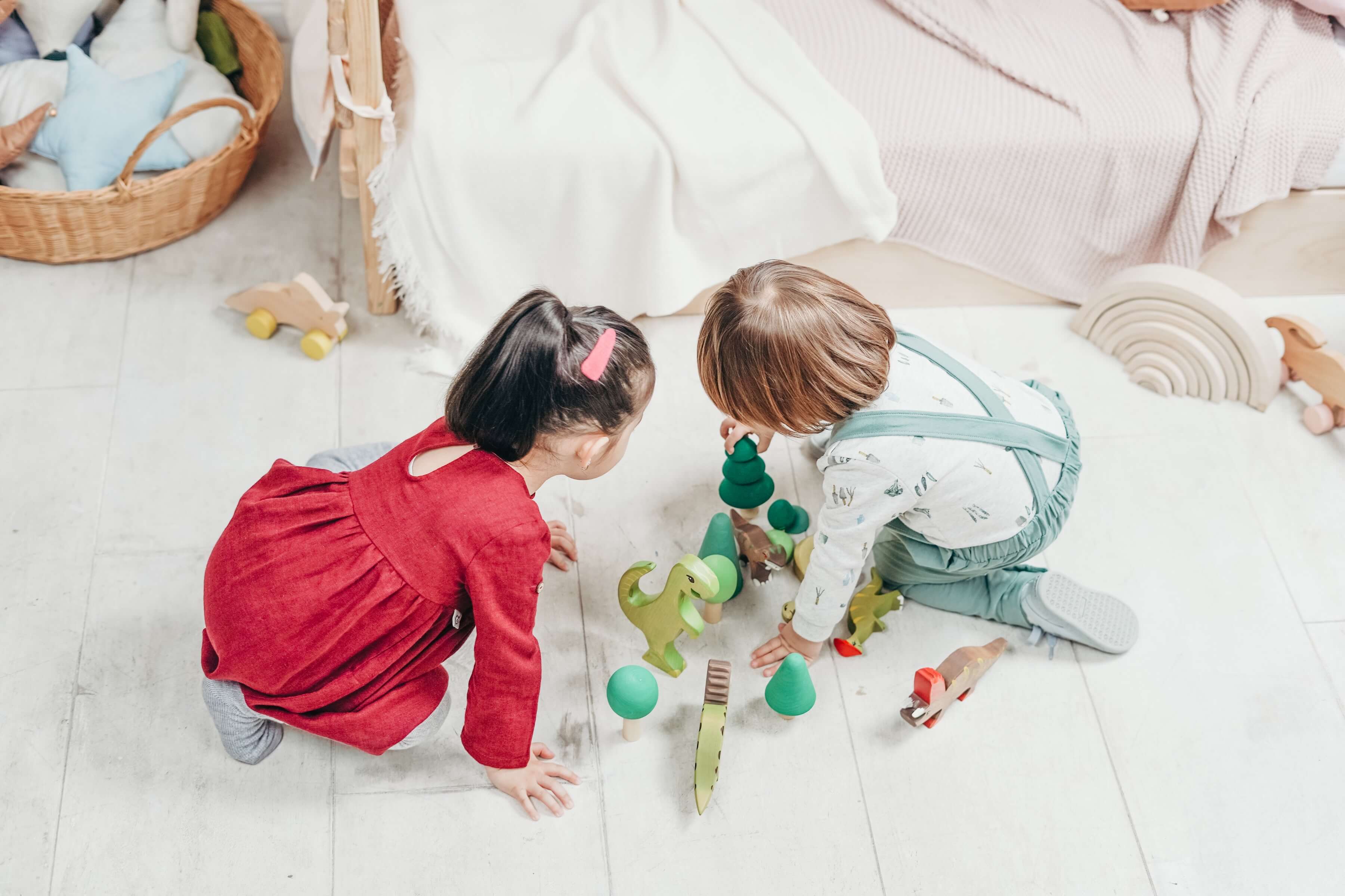 two toddlers playing with wooden sustainable toys