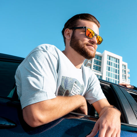 Guy hanging out of car window wearing sunglasses