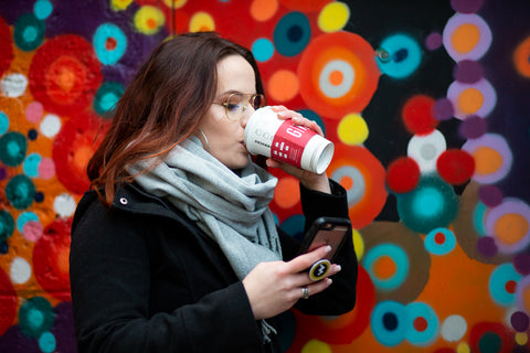 Women on phone drinking Starbucks coffee with clear glasses