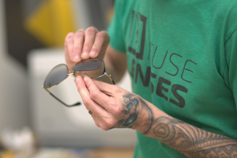 Hands place lenses into a glasses frame