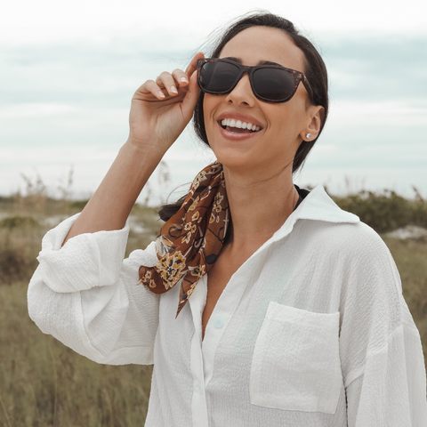 Woman on beach wearing stylish sunglasses