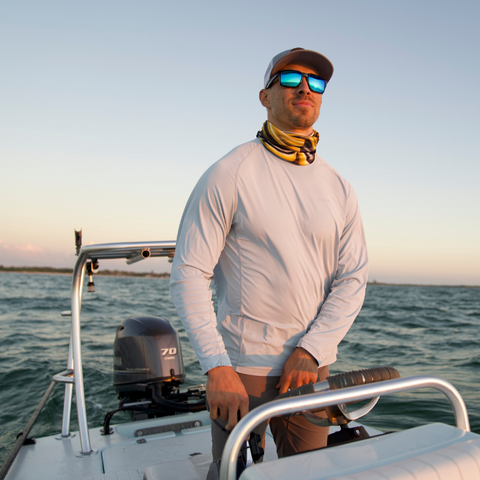 Man wearing sunglasses steering boat in the ocean