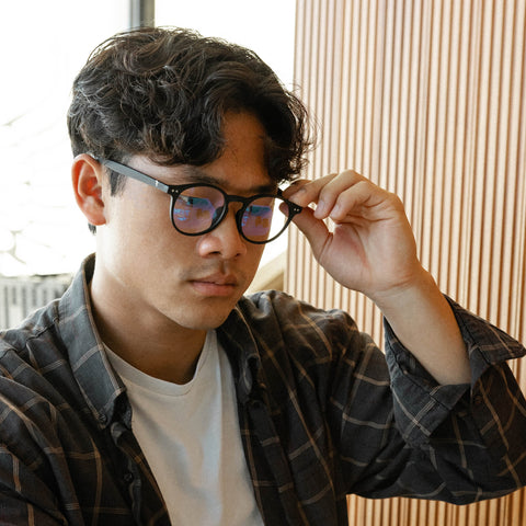 Young man wearing blue-light glasses at table