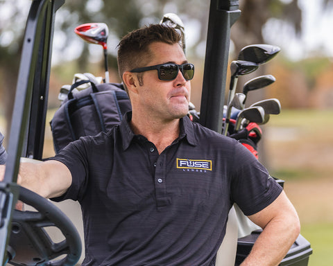 Man driving golf cart, wearing Fuse AMP color enhancing lenses