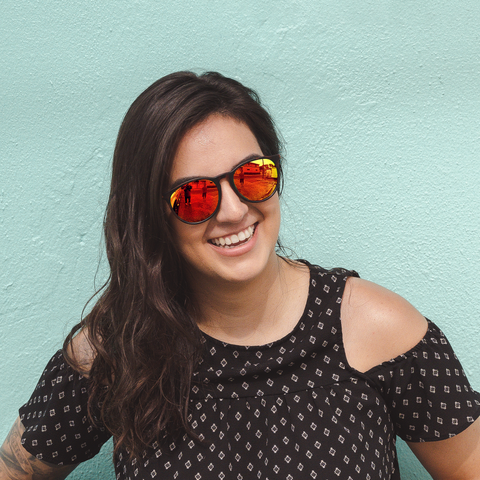 A woman in mirrored lenses laughs with a smile
