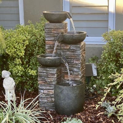 Pots and bricks fountain in a garden.