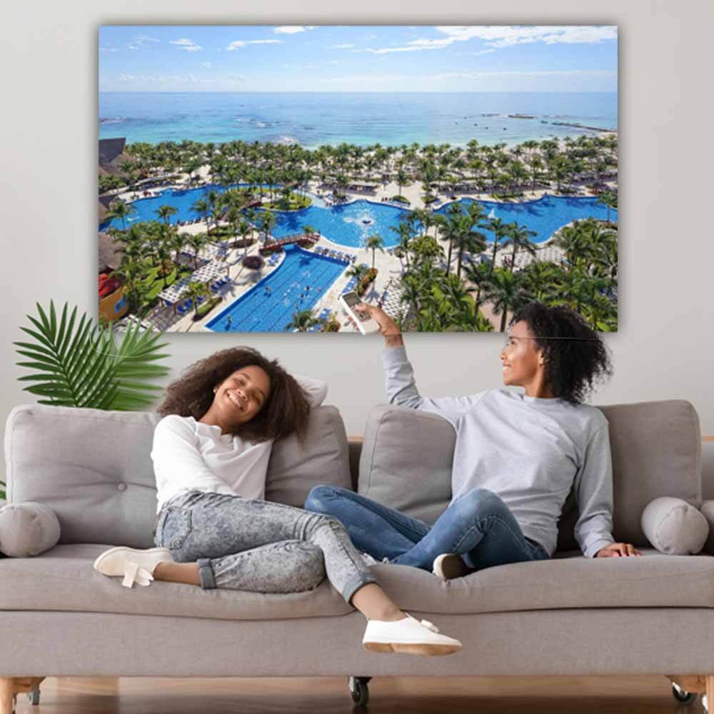 Two people sitting on a couch in front of a Wallhogs gloss poster