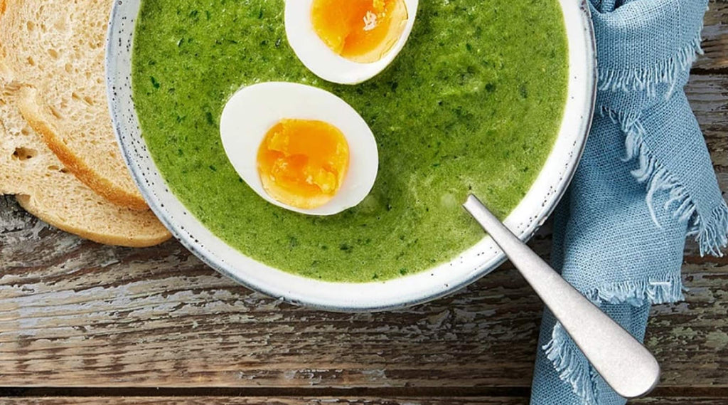 Image of spinach soup in a deep plate with egg halves