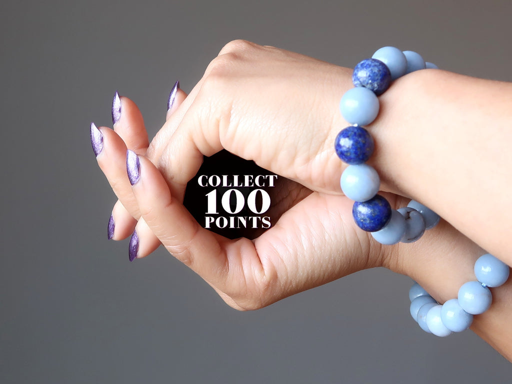 hands wearing blue angelite and lapis bracelets forming a cave with the word collect 100 points written inside