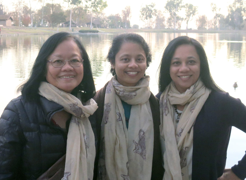 satin mother and daughters posing by a lake