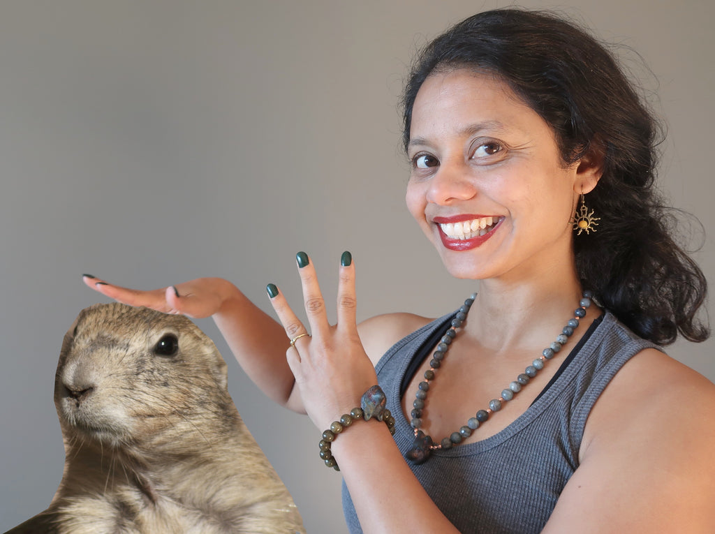 Sheila of Satin Crystals holding up three fingers and petting a Groundhog