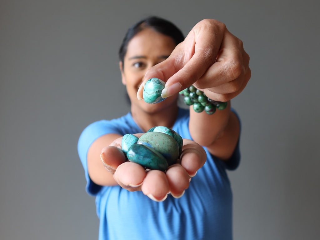 woman holding chrysocolla tumbled stones