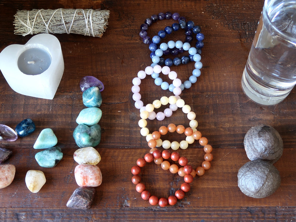 chakra stones, water, moqui marbles, sage and candle for meditation preparation