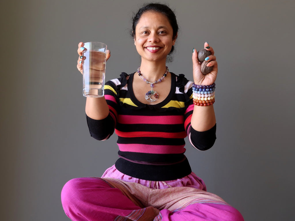 sheila of satin crystals holding up water and moqui marbles for post meditation grounding