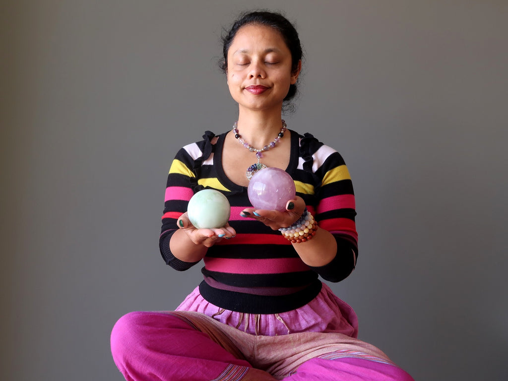 sheila of satin crystals meditating with green jade and pink rose quartz spheres at the heart chakra