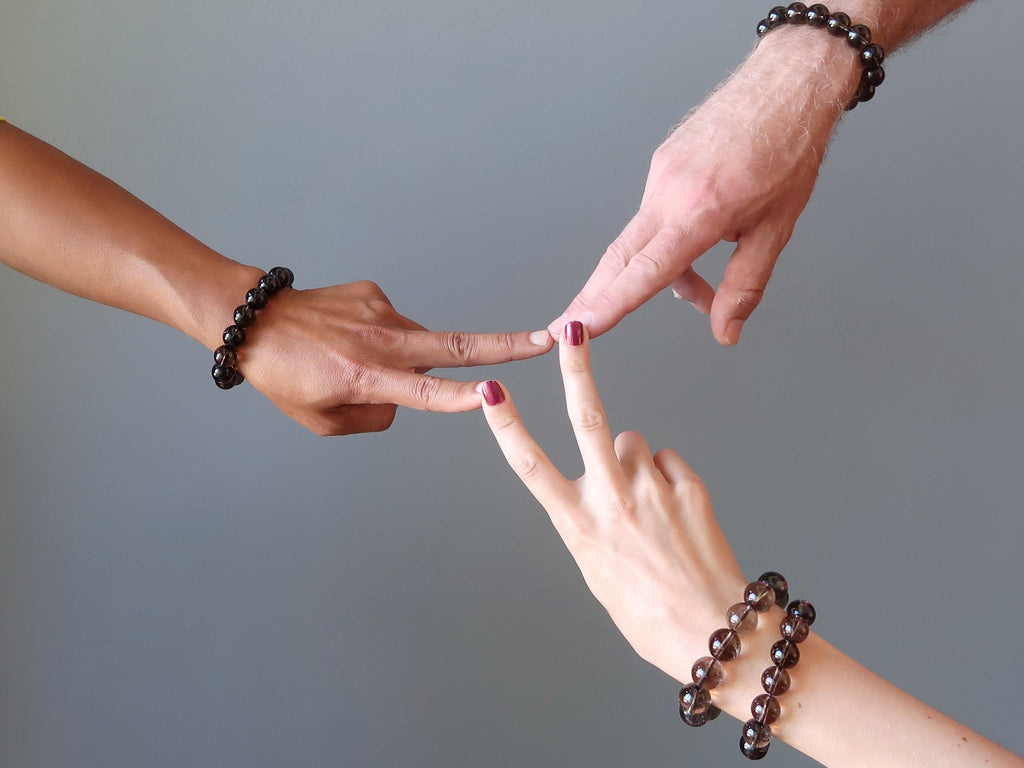 three hands coming together modeling smoky quartz bracelets