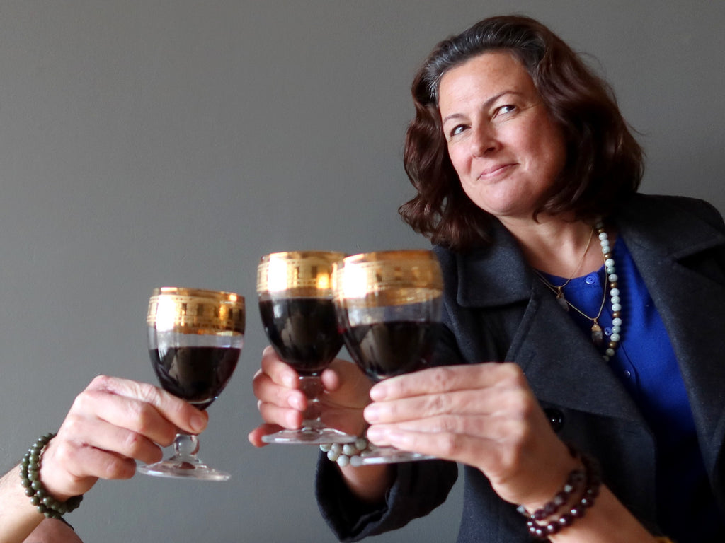 woman cheering wine with two others wearing abundance crystals