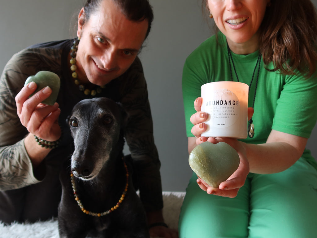 two people and a greyhound dog with aventurine hearts and abundance candle