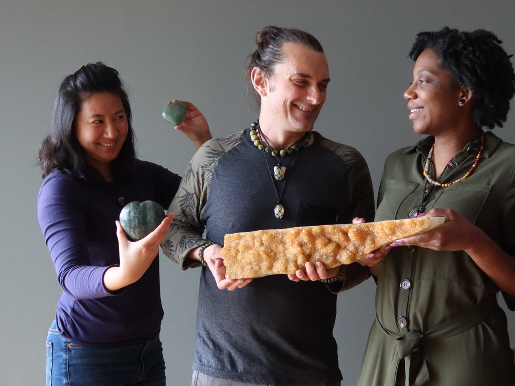 three people holding citrine cluster and aventurine hearts