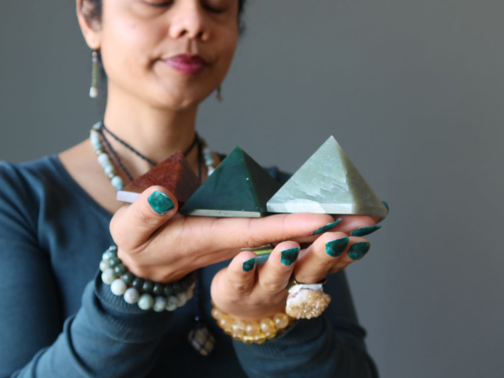 woman meditating with three aventurine pyramids