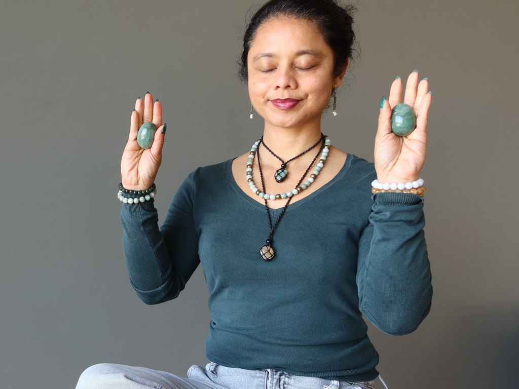 woman meditating with aventurine eggs