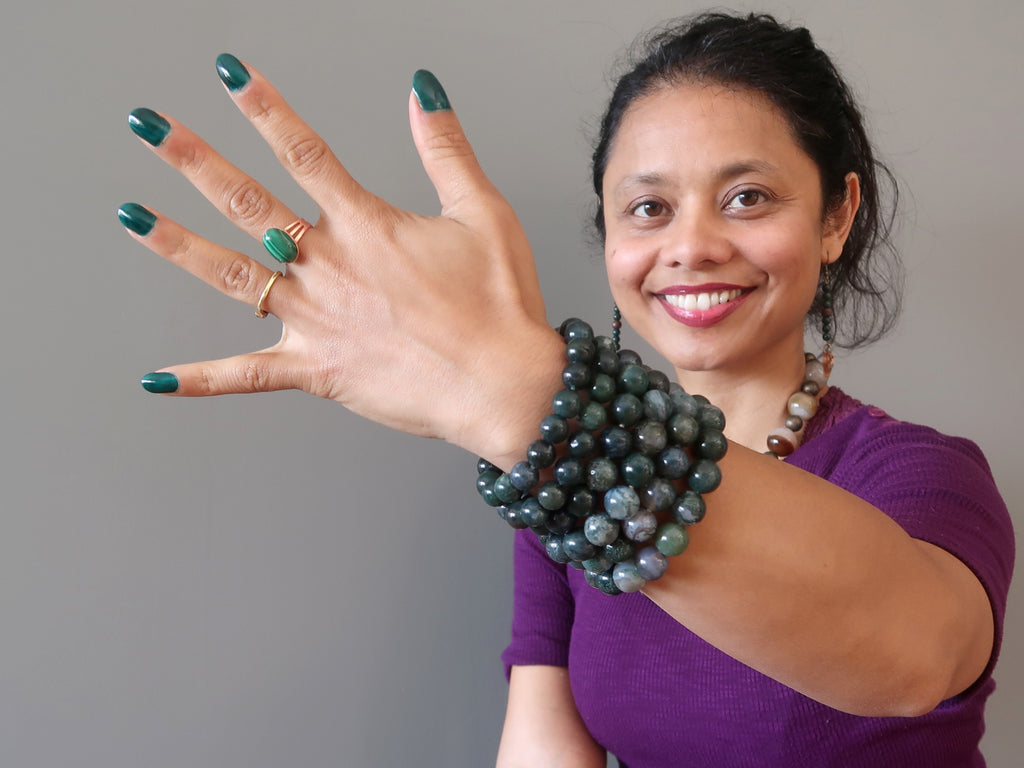 Wearing a stack of green moss agate bracelets