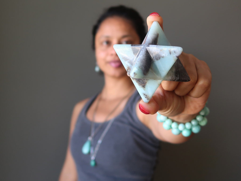 sheila of satin crystals holding a natural amazonite merkaba stone