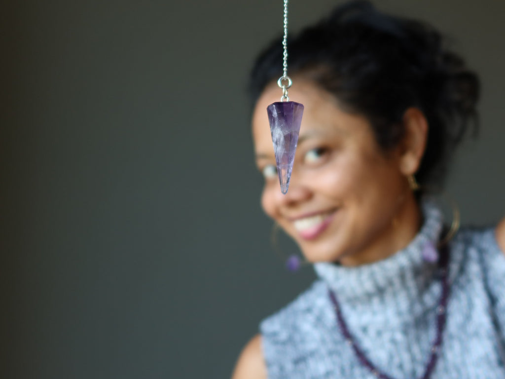 sheila of satin crystals with amethyst pendulum at her third eye chakra