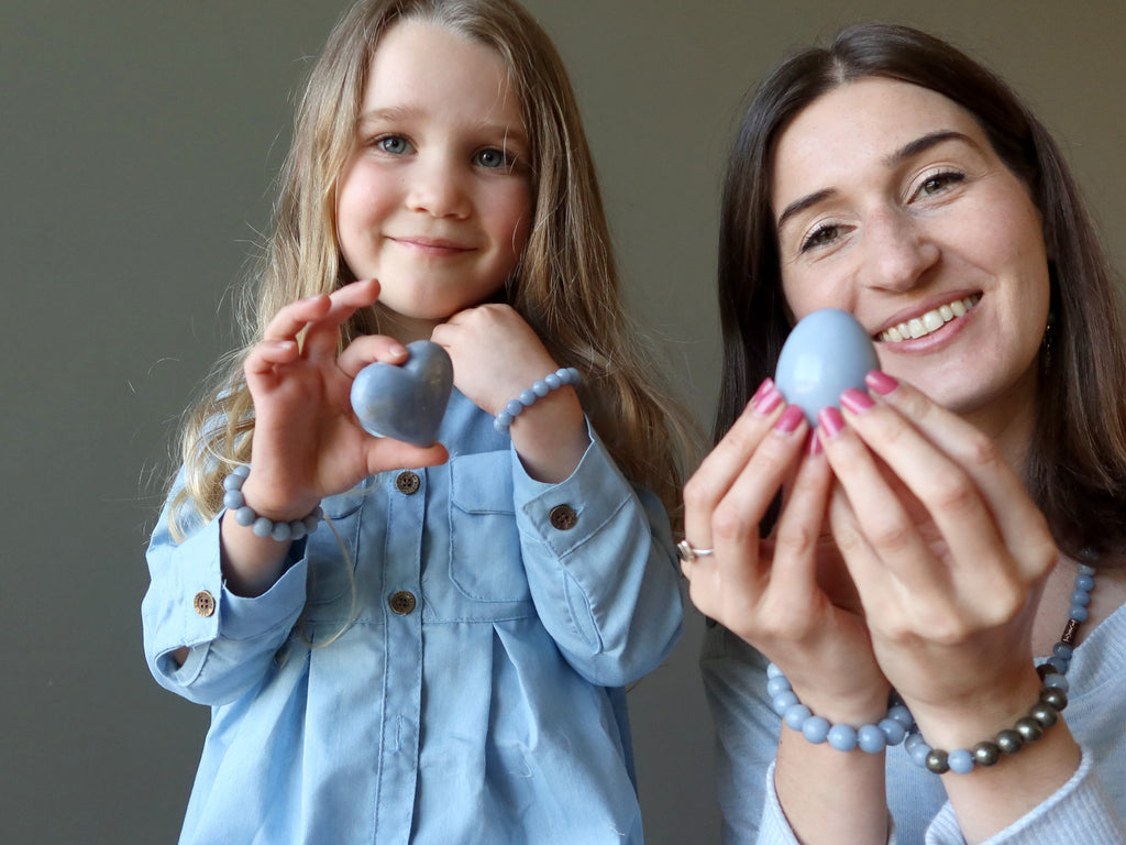 mother and daughter holding angelite crystals