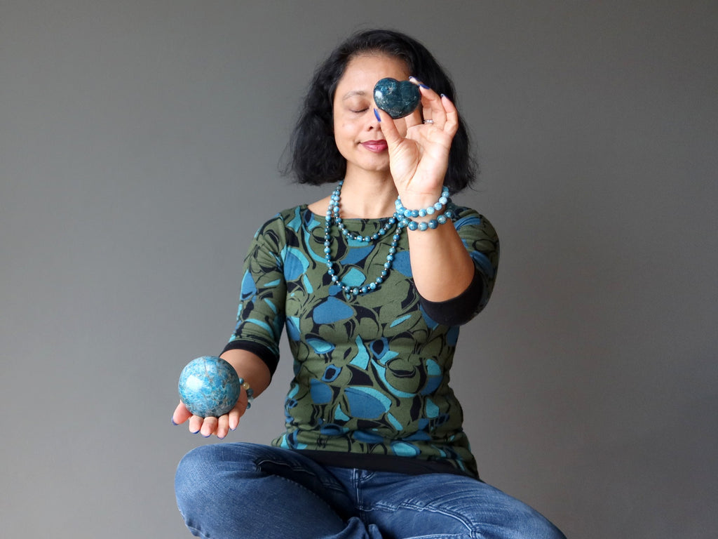 woman meditating with apatite heart and ball