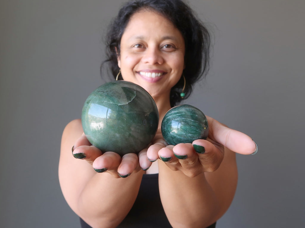 sheila of satin crystals holding two green aventurine crystal balls