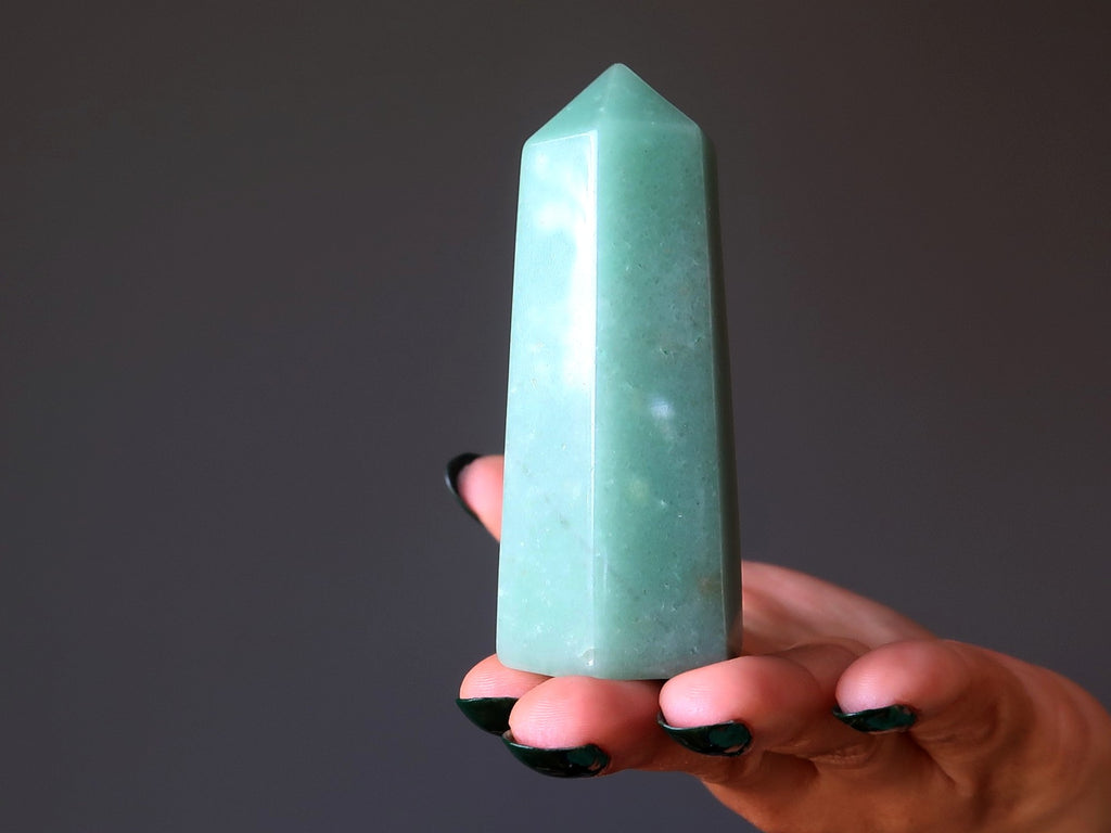 hand balancing a green aventurine tower