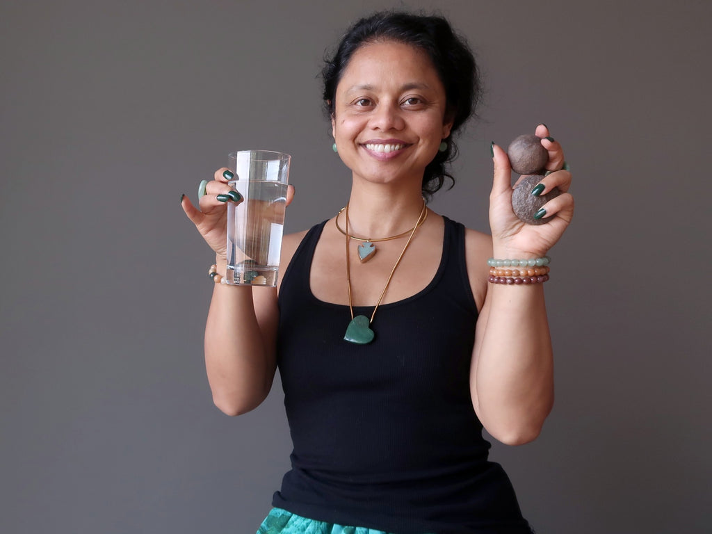 sheila of satin crystals holding moqui marble pair and a glass of water