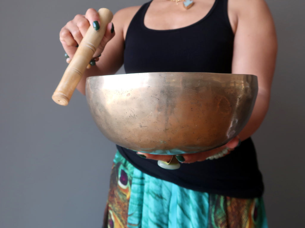 woman standing with tibetan singing bowl