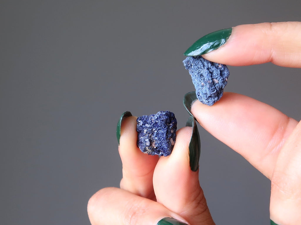 mains tenant deux pépites brutes de pierres précieuses naturelles d'azurite