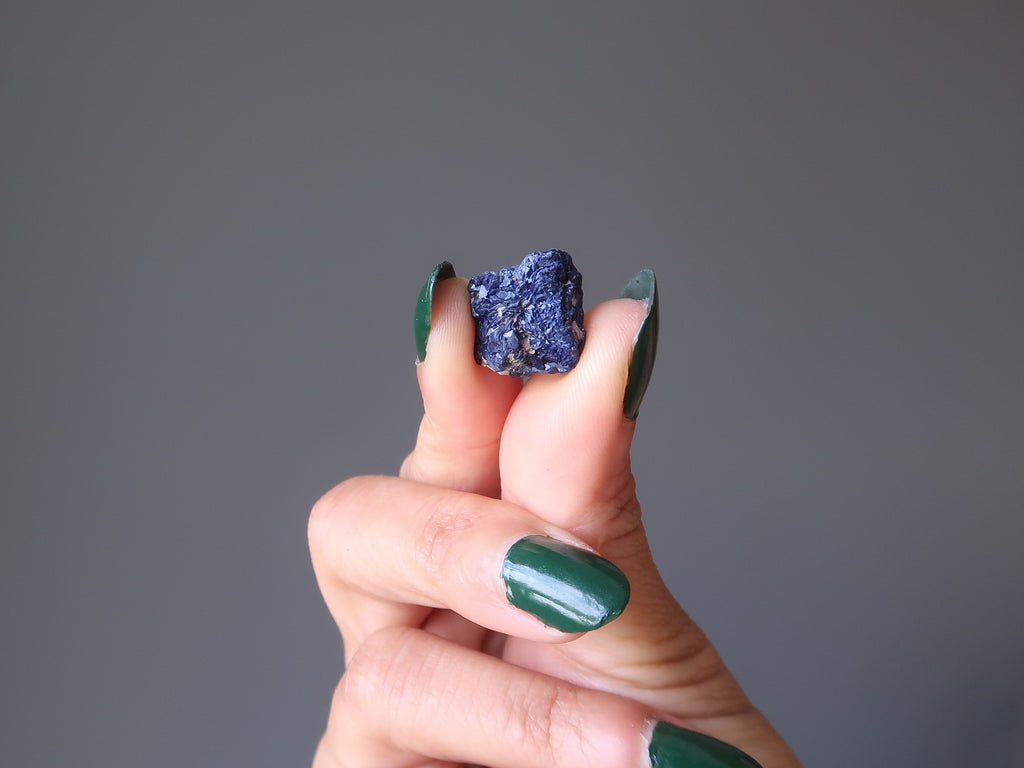 main tenant une pierre précieuse brute azurite bleu foncé