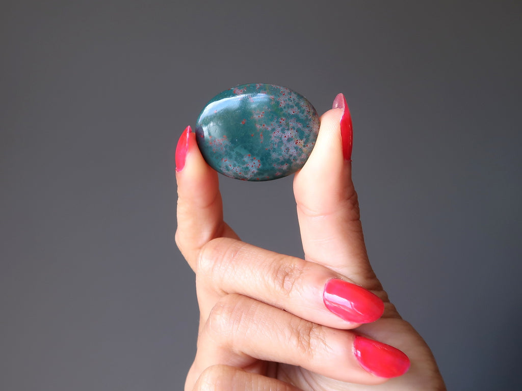 hand holding a bloodstone oval cabochon stone