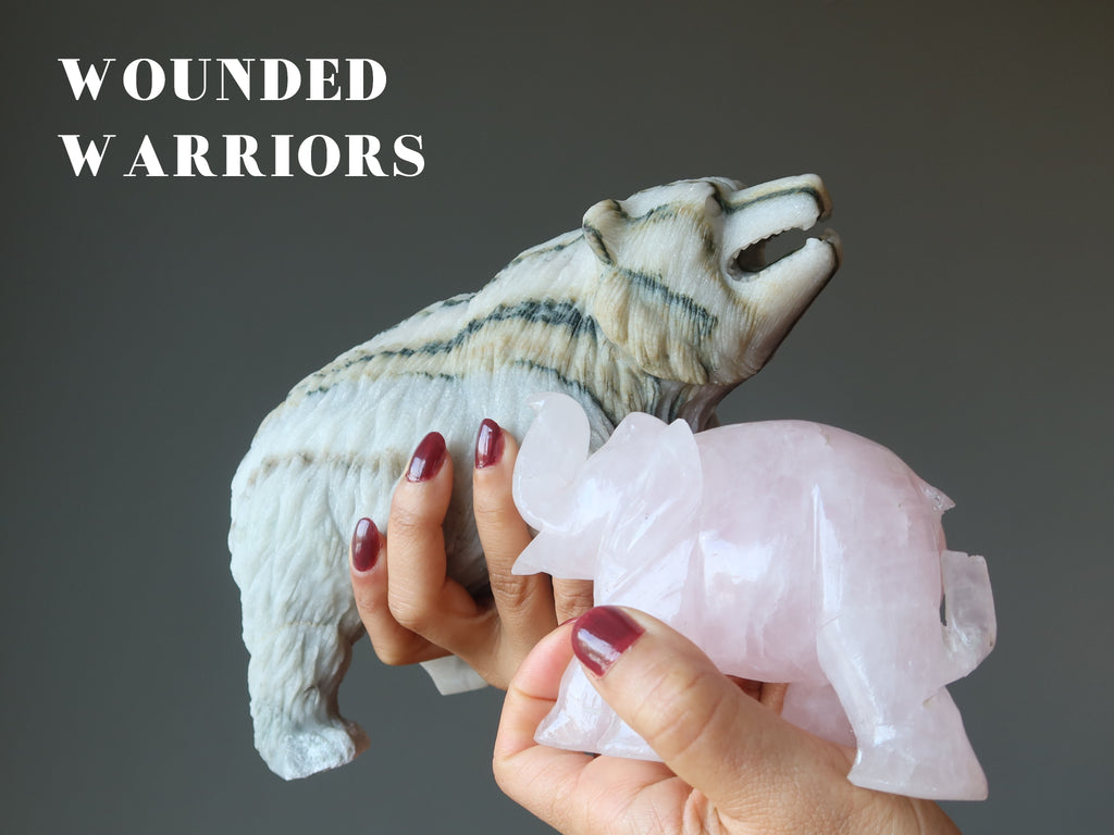 holding up two broken crystal animals known as wounded warriors