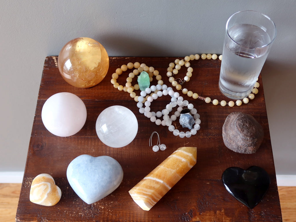 calcite stones and jewelry on table with water, moqui, obsidian