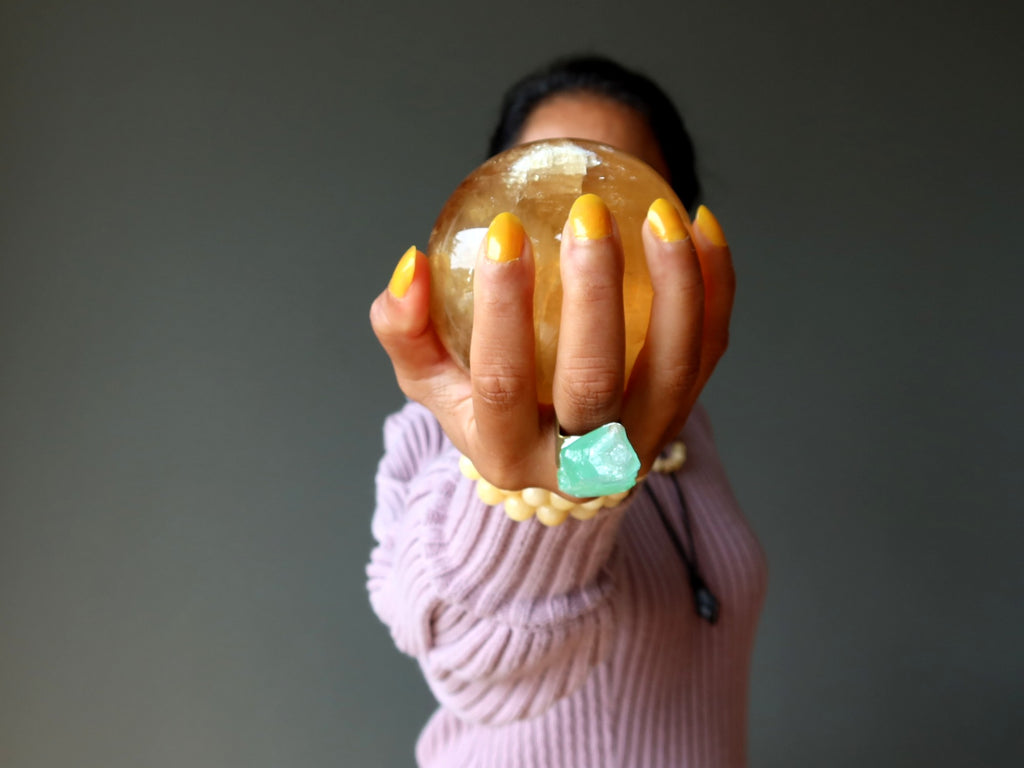 woman holding honey calcite ball