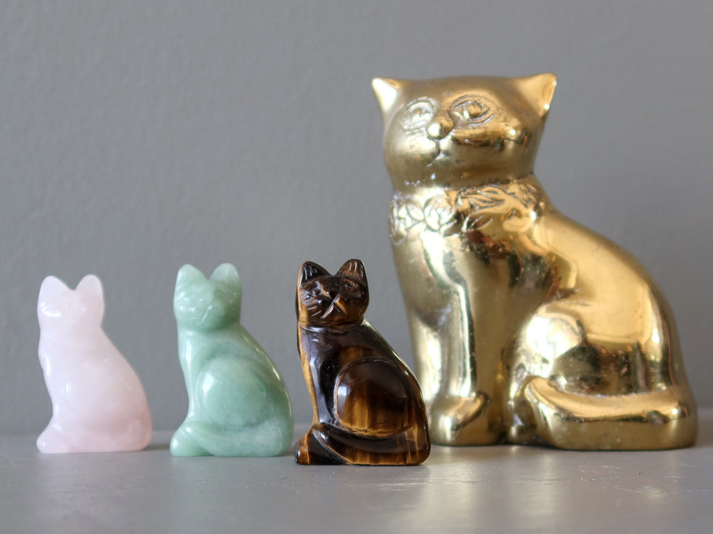 three gemstone and one metal cat figurine