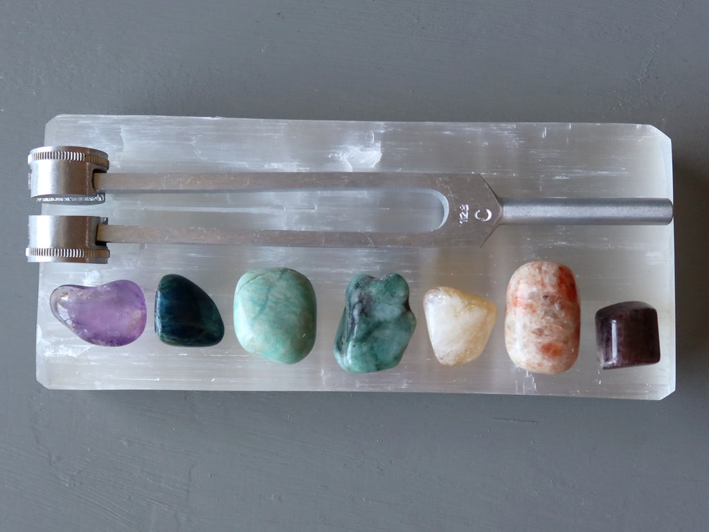 chakra stones on selenite with tuning fork