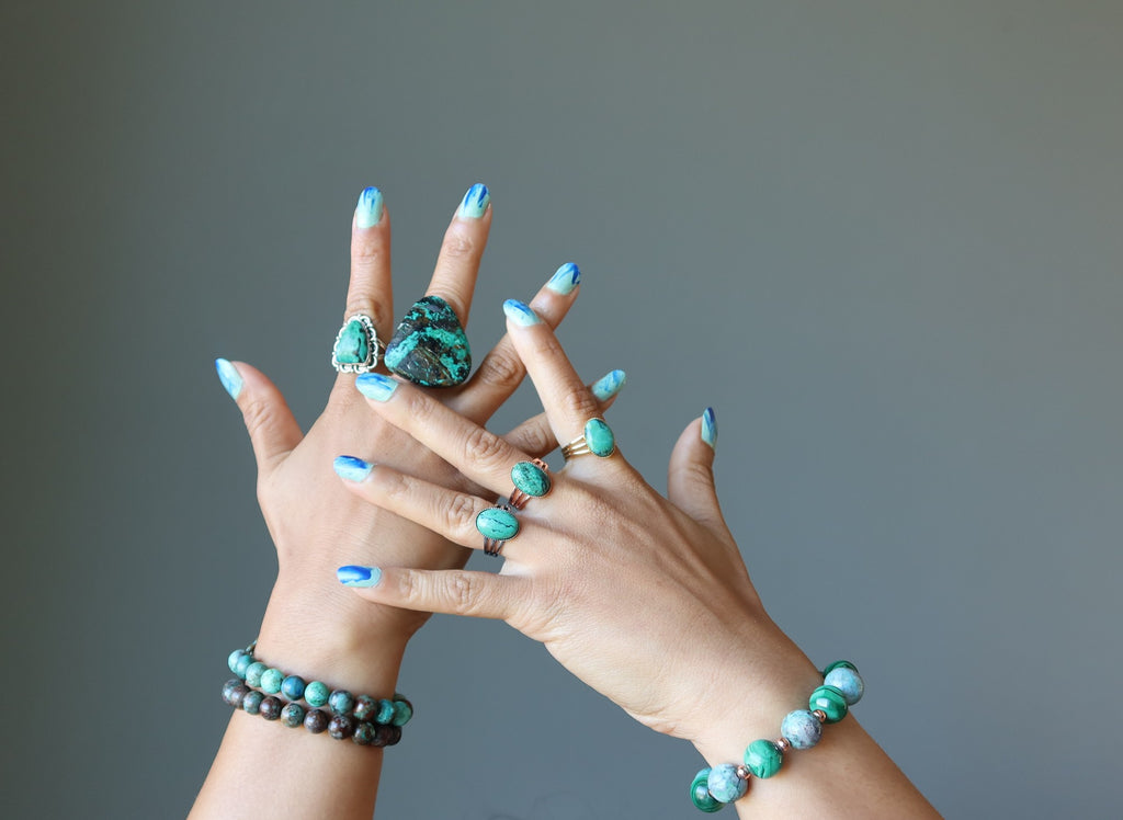 chrysocolla bracelets and rings on hands