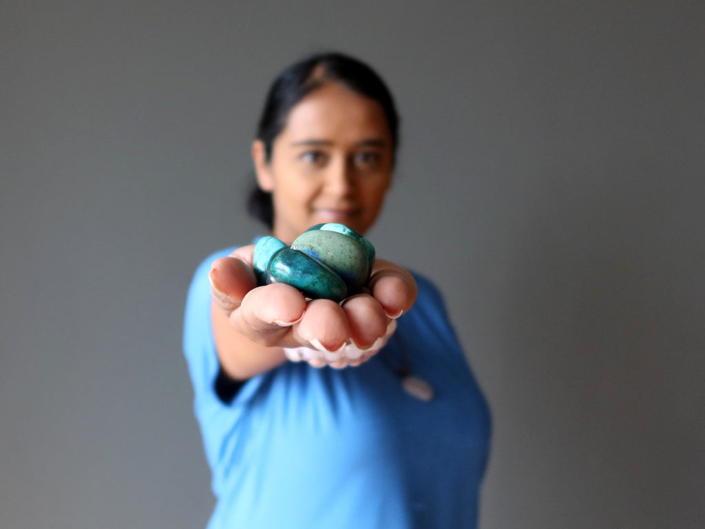 woman holding chrysocolla tumbled stones