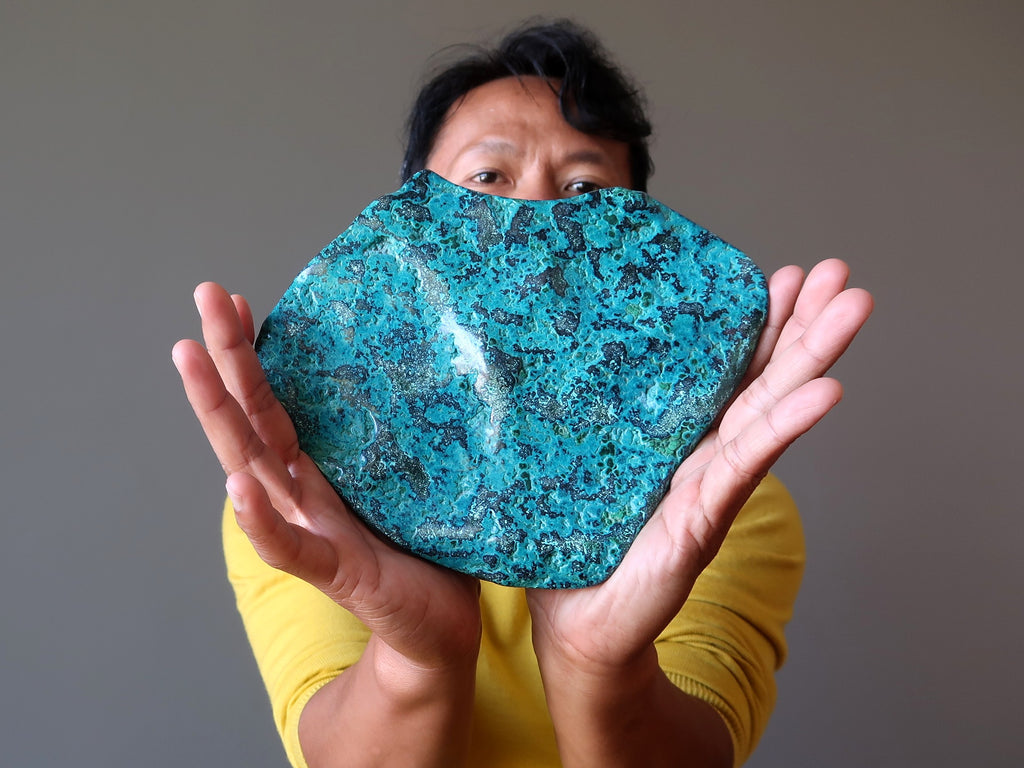 man holding large chrysocolla crystal