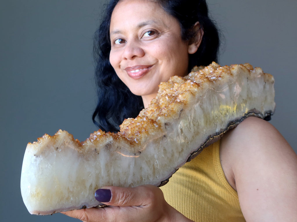 sheila of satin crystals holding a large citrine cluster geode