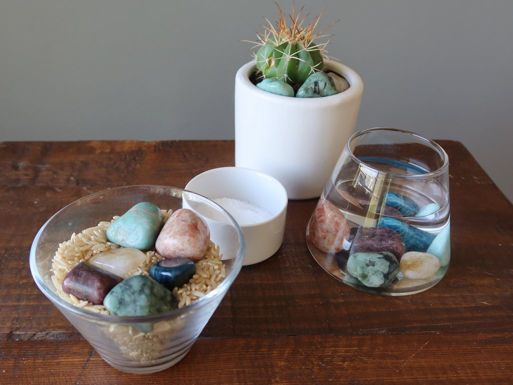 chakra crystals being cleaned in brown rice, water, potted plant and salt