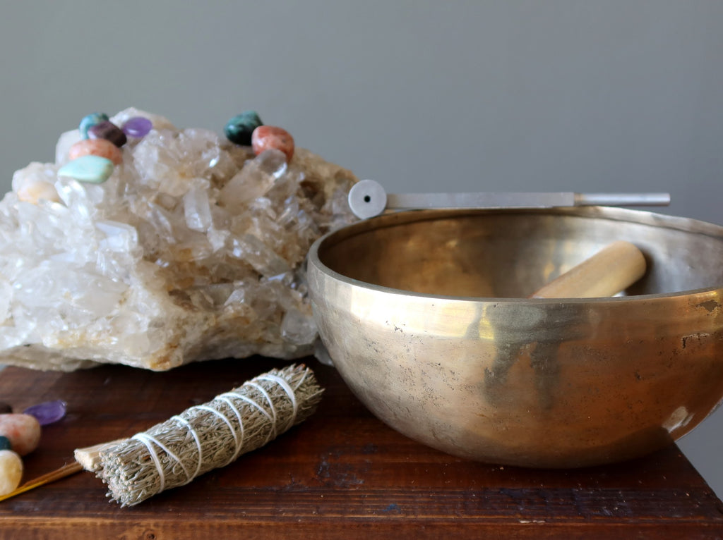 chakra stones on quartz cluster, singing bowl, tuning fork, sage for cleansing