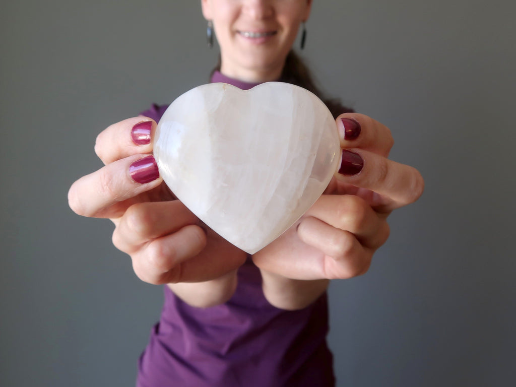 lucia of satin crystals holding a quartz heart for love and romance