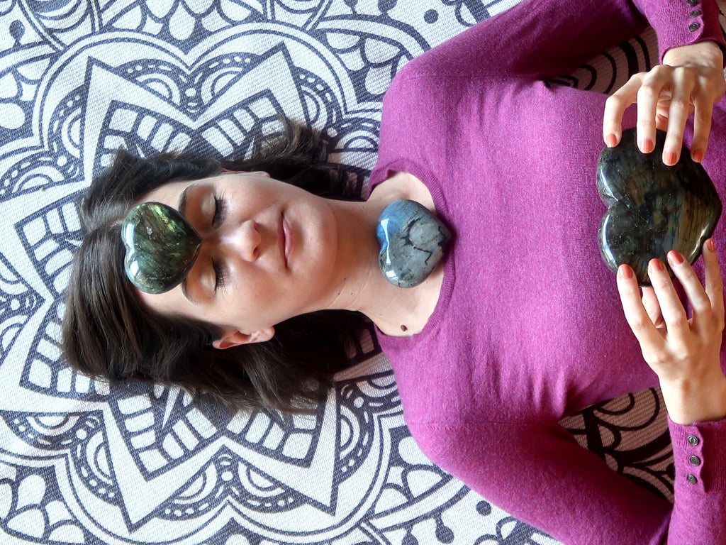 woman lying with labradorite hearts